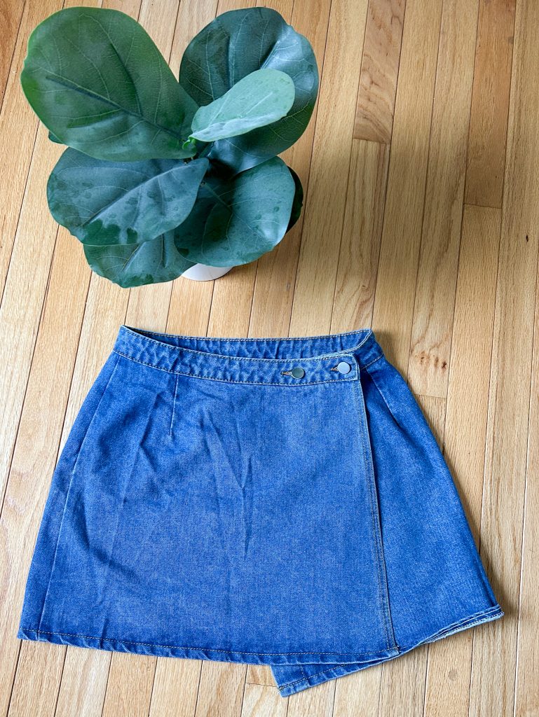 Denim wrap mini skirt next to a plant