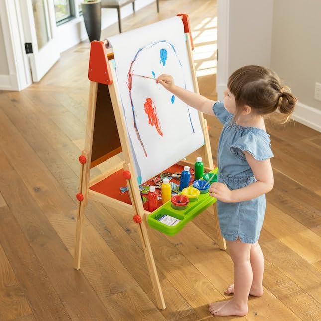Little girl playing with art easel