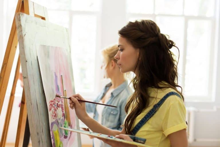 Brunette woman painting on easel