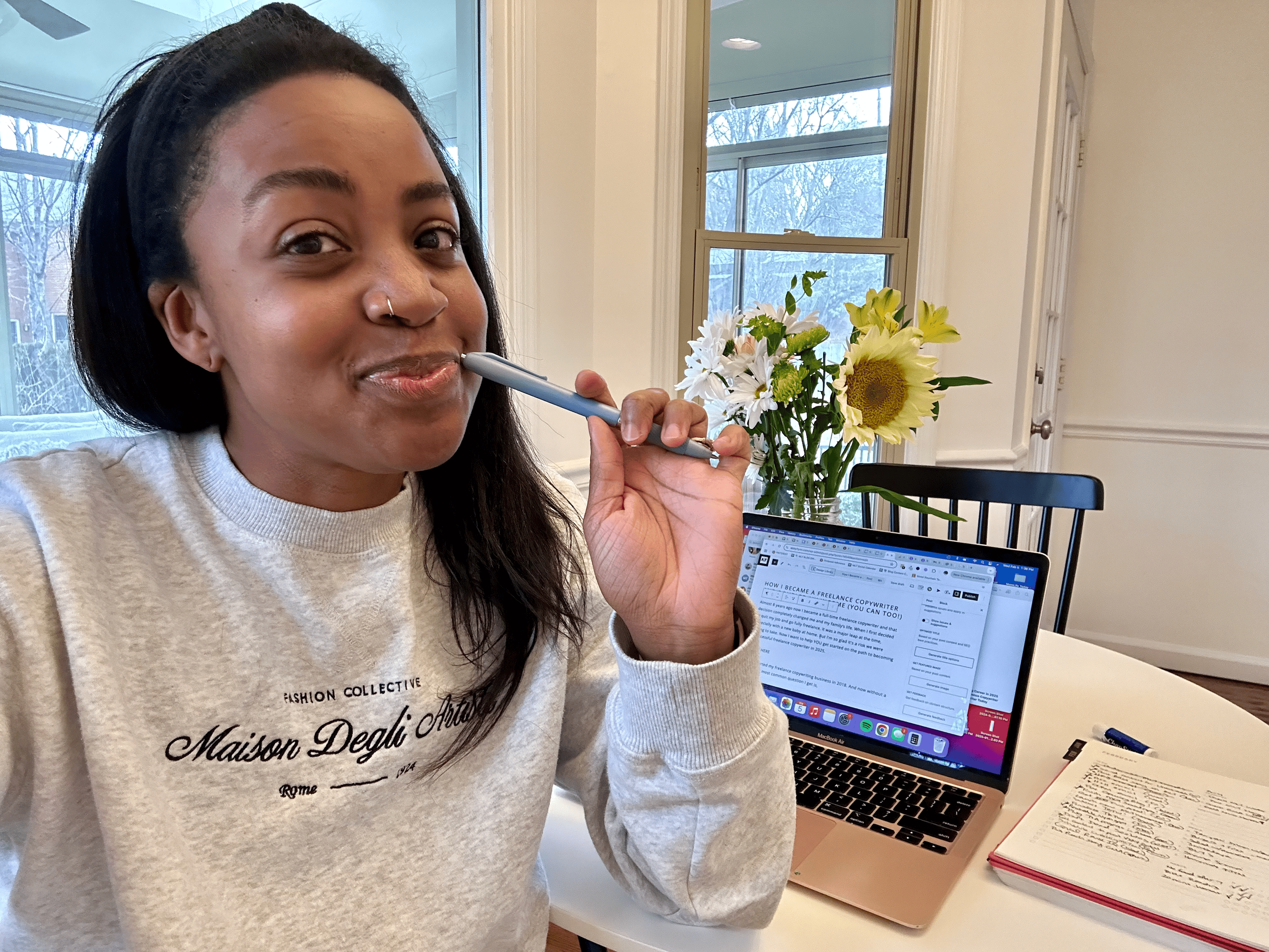 Abby Flynn copywriter sitting at computer with flowers